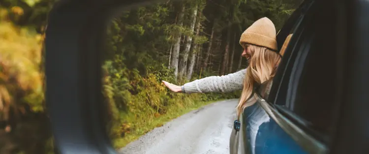 Girl waving hands outside the car
