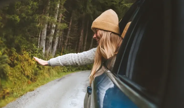Girl waving hands outside the car